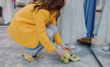 Starsza kobieta mierzy kolorowe buty w nowoczesnym sklepie obuwniczym