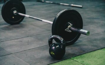Trening siłowy dla początkujących w Koziegłowach – jak bezpiecznie rozpocząć ćwiczenia na siłowni MEDIGYM Sztanga i kettlebell leżące na podłodze siłowni MEDIGYM