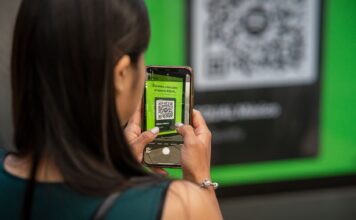 Kobieta skanuje kod QR smartfonem na ulicy Mexico City