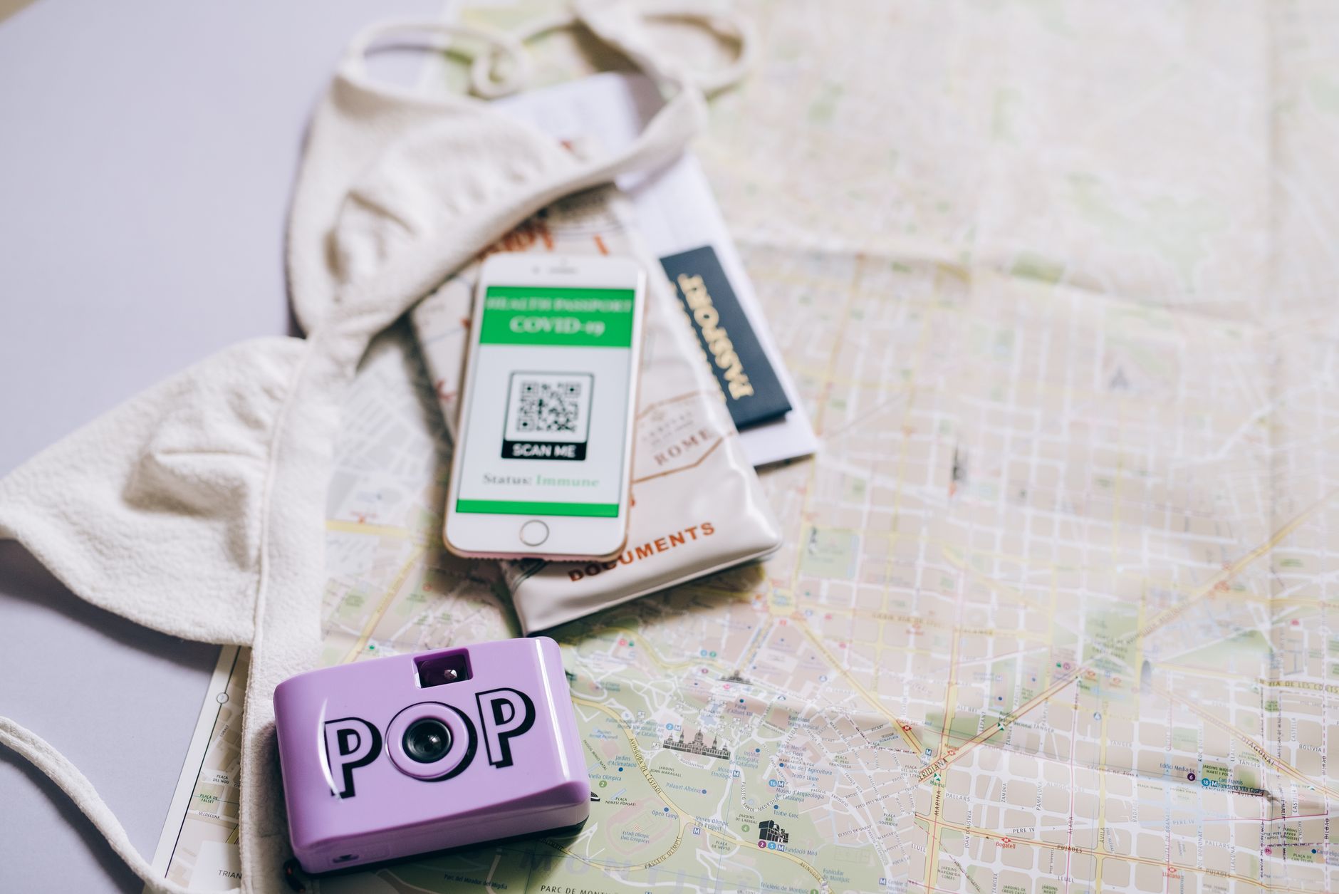 Paszport, mapa i smartfon z aparatem wśród akcesoriów podróżnych