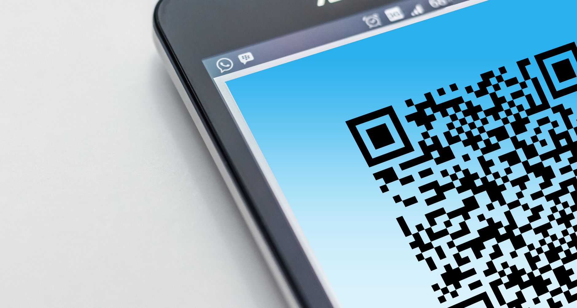Zbliżenie smartfona z wyświetlonym kodem QR na ekranie