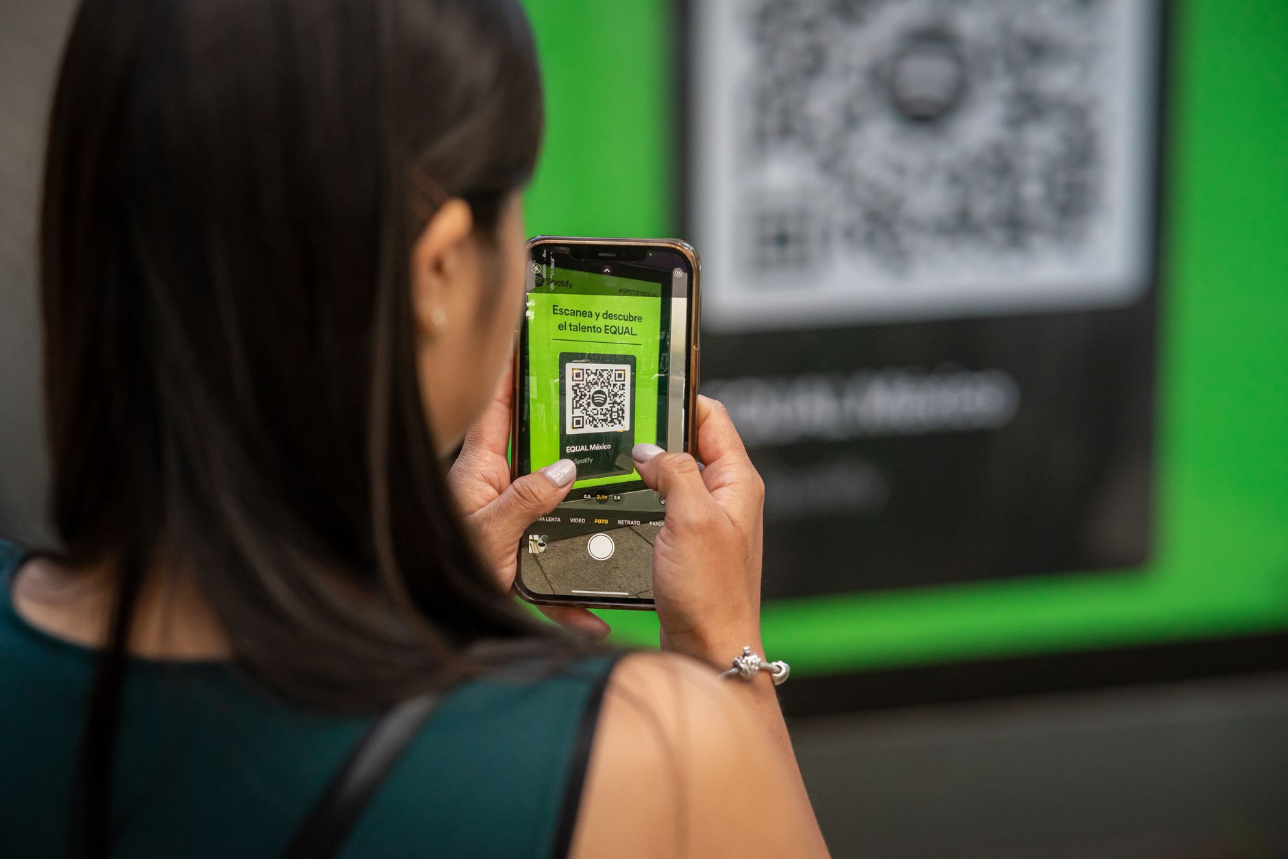 Kobieta skanuje kod QR smartfonem na ulicy podczas wydarzenia